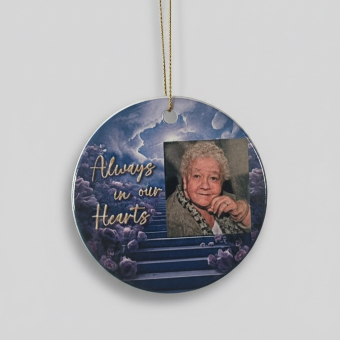 Circular ornament with a photo of an elderly woman and 'Always in our Hearts' text on a white background.